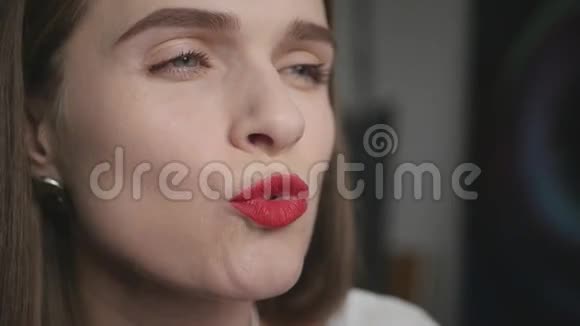 鲜艳的女孩用漂亮的红色口红微笑亲吻嘴唇高清1920x1080视频的预览图