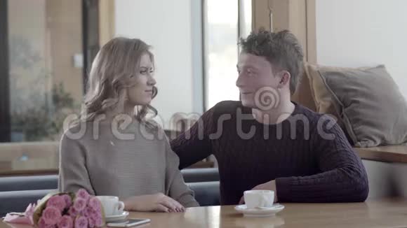 一对情侣在咖啡馆恋爱一个男人在情人节送礼物视频的预览图