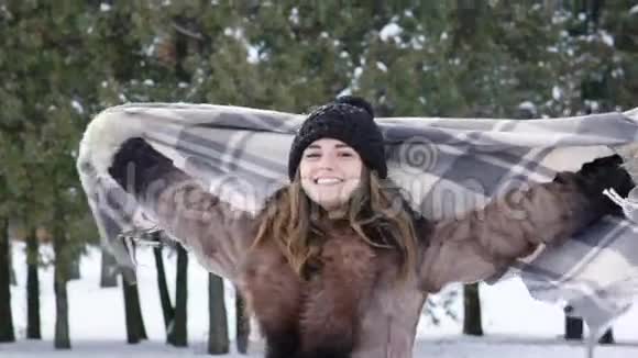 快乐的女孩在冬季公园里用格子呢转过身慢慢地视频的预览图
