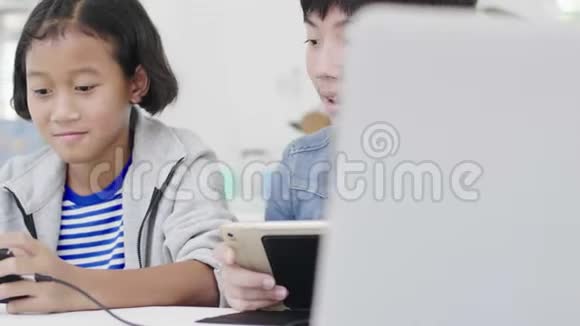 接近亚洲可爱的女孩和小男孩在智能手机上玩竞争性电子游戏视频的预览图