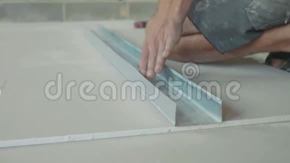 工人在一张干壁板上做标记以便在新建的房子里安装视频的预览图