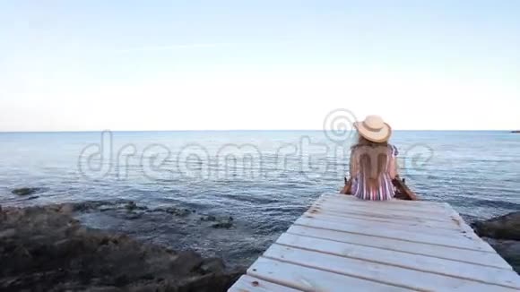 坐在码头上的年轻女子视频的预览图