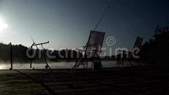 站在钓鱼码头的钓鱼椅背景是清晨的雾河视频的预览图