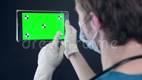 男医生拿着绿色屏幕浏览数字平板电脑视频的预览图