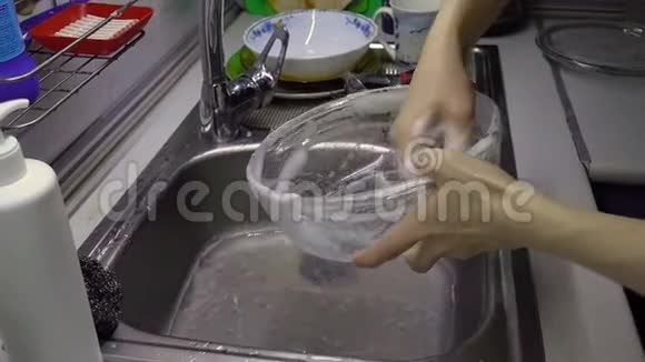 女人洗和冲洗玻璃盘子视频的预览图