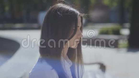 城市街道阳光明媚的一天一位身穿白衬衫的年轻女子的肖像特写视频的预览图