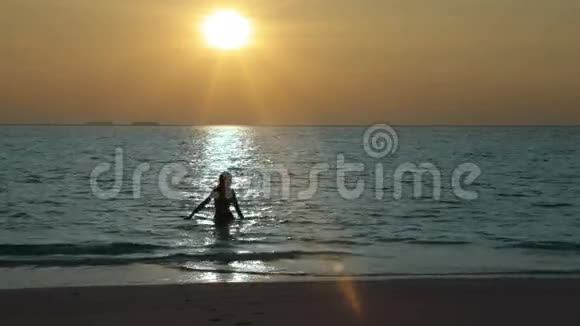 日落时分离开大海的女人的剪影视频的预览图