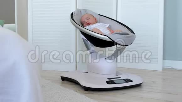 可爱的新生婴儿睡在白色房间里的保镖椅子上视频的预览图