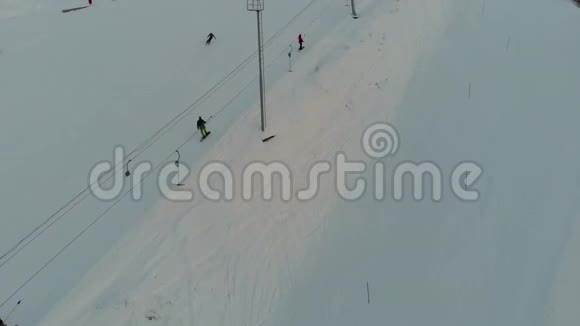 滑雪者和滑雪者在滑雪场的山上爬山空中观景4K视频的预览图