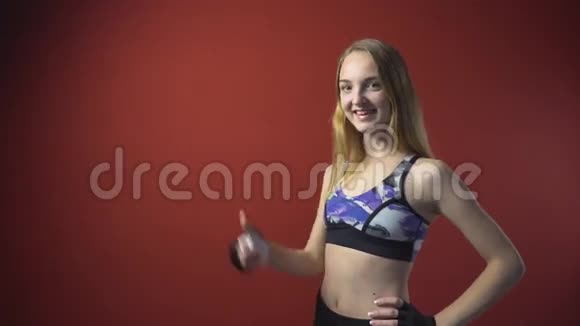 年轻迷人的健身女孩竖起大拇指视频的预览图