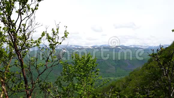 绿色山谷中白雪皑皑的群山和丘陵的景色视频的预览图
