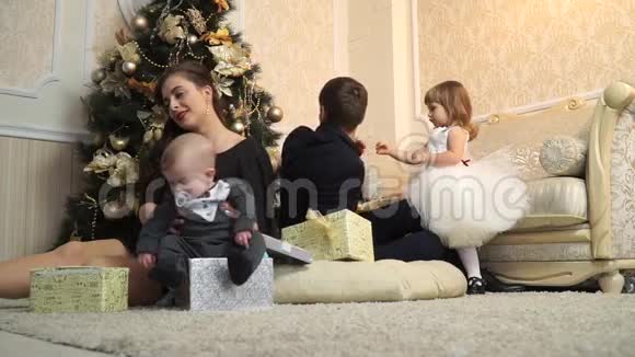 圣诞树下有礼物的小美丽家庭视频的预览图