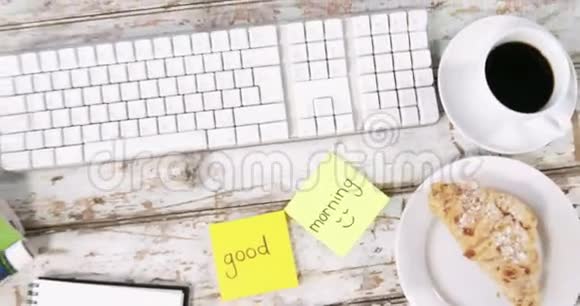 键盘一杯茶面包和带有早安的便笺视频的预览图
