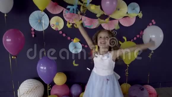 漂亮的女婴扔着鲜艳的纸屑庆祝她的生日聚会视频的预览图