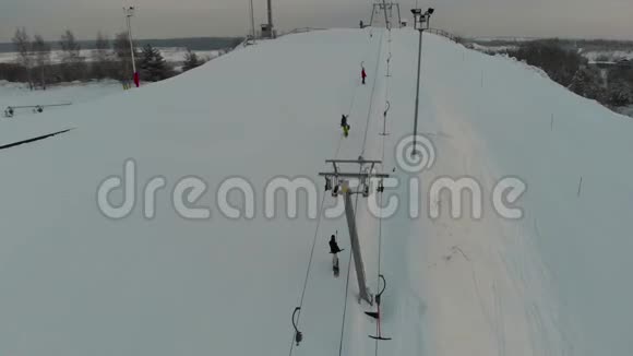 滑雪者和滑雪者在滑雪场的山上爬山空中观景4K视频的预览图