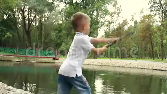 小孩在湖里扔鱼竿钓鱼视频的预览图
