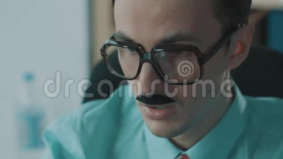 年轻的男办公室工作人员戴着巨大的眼镜和滑稽的胡子打哈欠视频的预览图