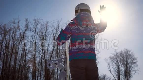 大气框架梦想和欢乐的概念一个滑雪的女孩用手抓住了一个明亮的太阳A视频的预览图
