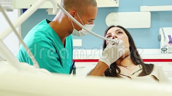 男牙科医生治疗年轻女性牙齿视频的预览图