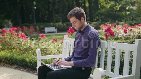 公园里疲惫的年轻人用笔记本电脑视频的预览图
