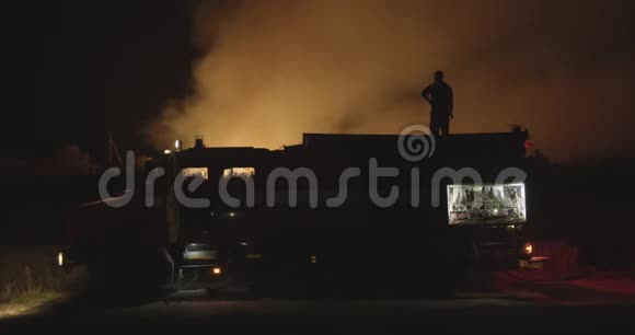 背景燃烧场上有闪光灯的消防车视频的预览图