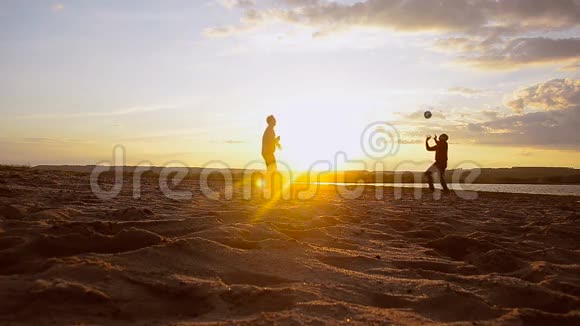 训练男子在阳光下在沙滩上打排球夏天晚上在沙滩上打排球视频的预览图