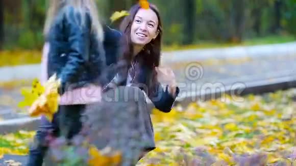 小女孩和快乐的妈妈喜欢秋天在户外公园秋季家庭假期视频的预览图
