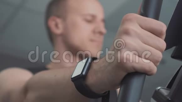 带着智能手表的年轻人骑着健身车视频的预览图