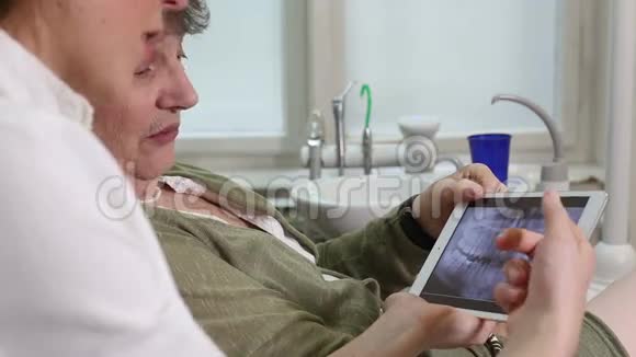 牙科医生的侧视图向她的病人显示X光牙齿视频的预览图