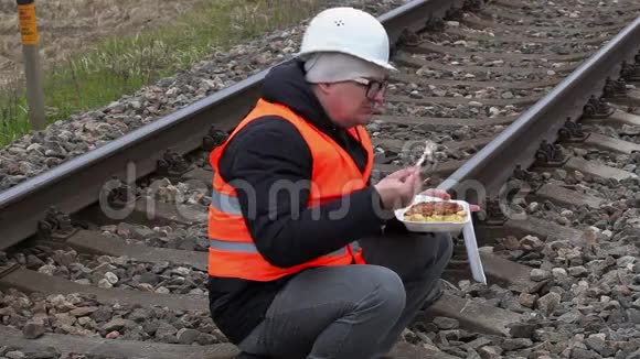 工人坐在铁路上吃饭视频的预览图