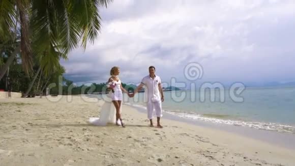 新娘和新郎沿着海滩散步视频的预览图