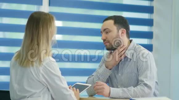男喉痛病人在接待处预约医生视频的预览图