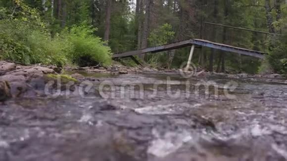 梯级瀑布快速流动的瀑布河流在木桥下流动进入前景视频的预览图