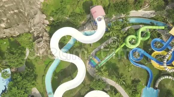 无人机在游乐水上乐园观看多彩的水上滑梯人们在户外水上公园玩滑梯夏季视频的预览图