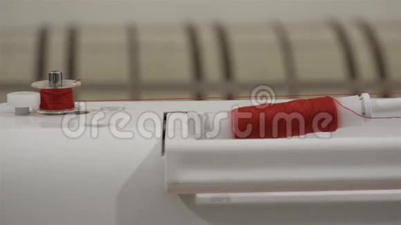 缝纫机上红色线轴的快速筒子缝衣服视频的预览图