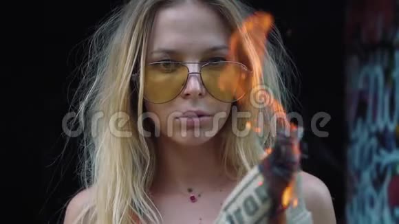年轻的金发女孩怪物手里拿着一把火把咄咄逼人地看着相机格林斯姿势慢镜头拍摄视频的预览图