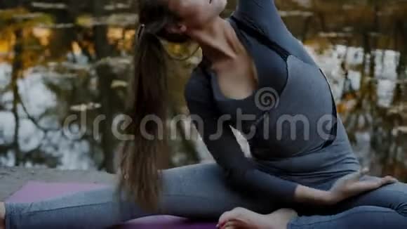 年轻女子在秋城公园做瑜伽练习健康生活方式概念视频的预览图