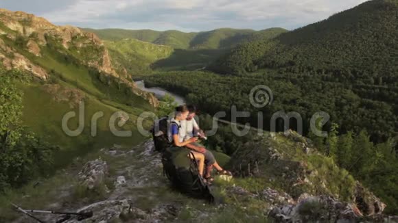 背包客夫妇在岩山休息视频的预览图