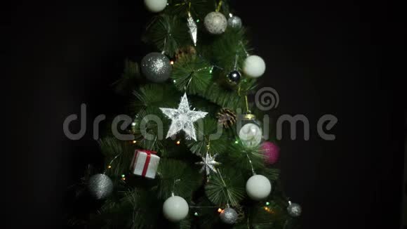 带有圣诞球和圣诞树上的灯的黑色背景视频的预览图