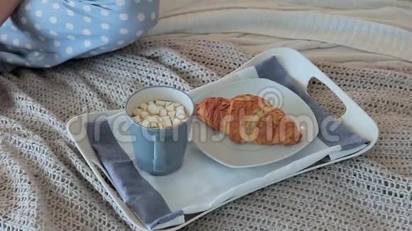为一位年轻迷人的女士提供带咖啡和羊角面包的早餐视频的预览图