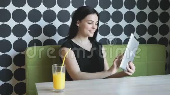 女孩用银色电脑平板电脑看照片视频的预览图