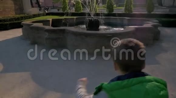 捷克共和国布拉格小男孩跑到喷泉边往水中扔硬币的慢镜头视频的预览图