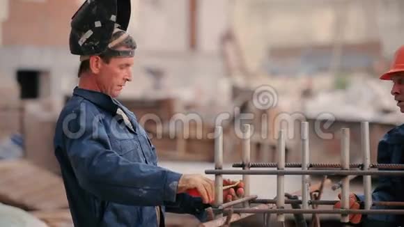 老建筑工人焊接一根管道到建筑视频的预览图