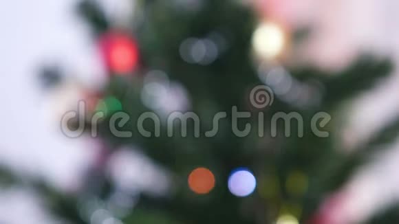 圣诞树树枝上的红色闪亮的球和金色玩具圣诞树上有灯光的圣诞花环视频的预览图