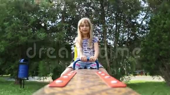 坐跷跷板的小女孩视频的预览图