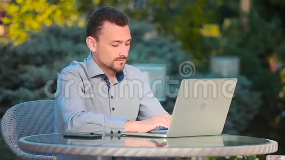 坐在外面键盘上打字的年轻人视频的预览图