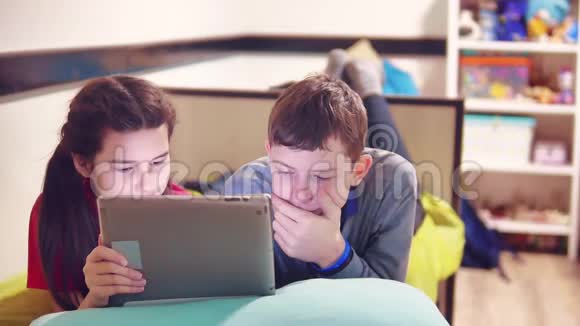 小男孩和小女孩在玩狗在平板上躺在床上青少年及青少年社交网站视频的预览图