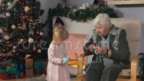 祖母坐在椅子上时编织袜子视频的预览图