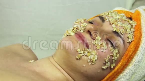 女孩脸上的燕麦片家庭化妆品面膜视频的预览图