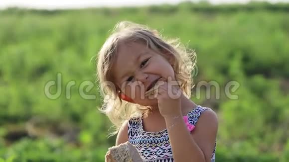 有机生态农场田里小女孩吃家常面包的画像视频的预览图